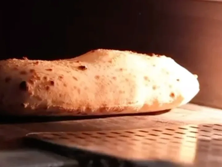Pizza intrând pe lopată în cuptorul încins