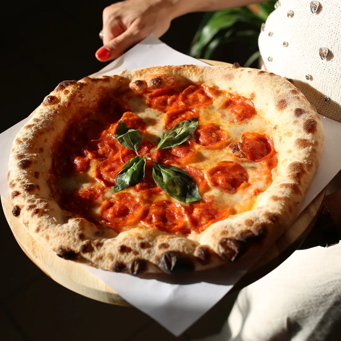Felie de pizza marinara cu salam, ridicată din pizza
