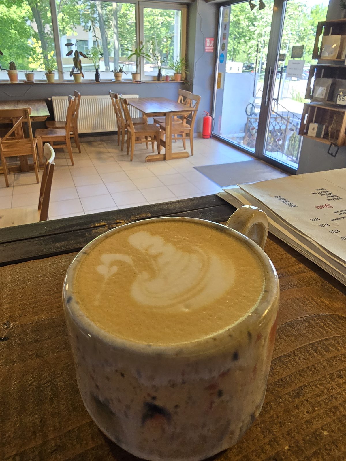 Cappuccino cu latte art în cană de ceramică, pe barul MANCAVE
